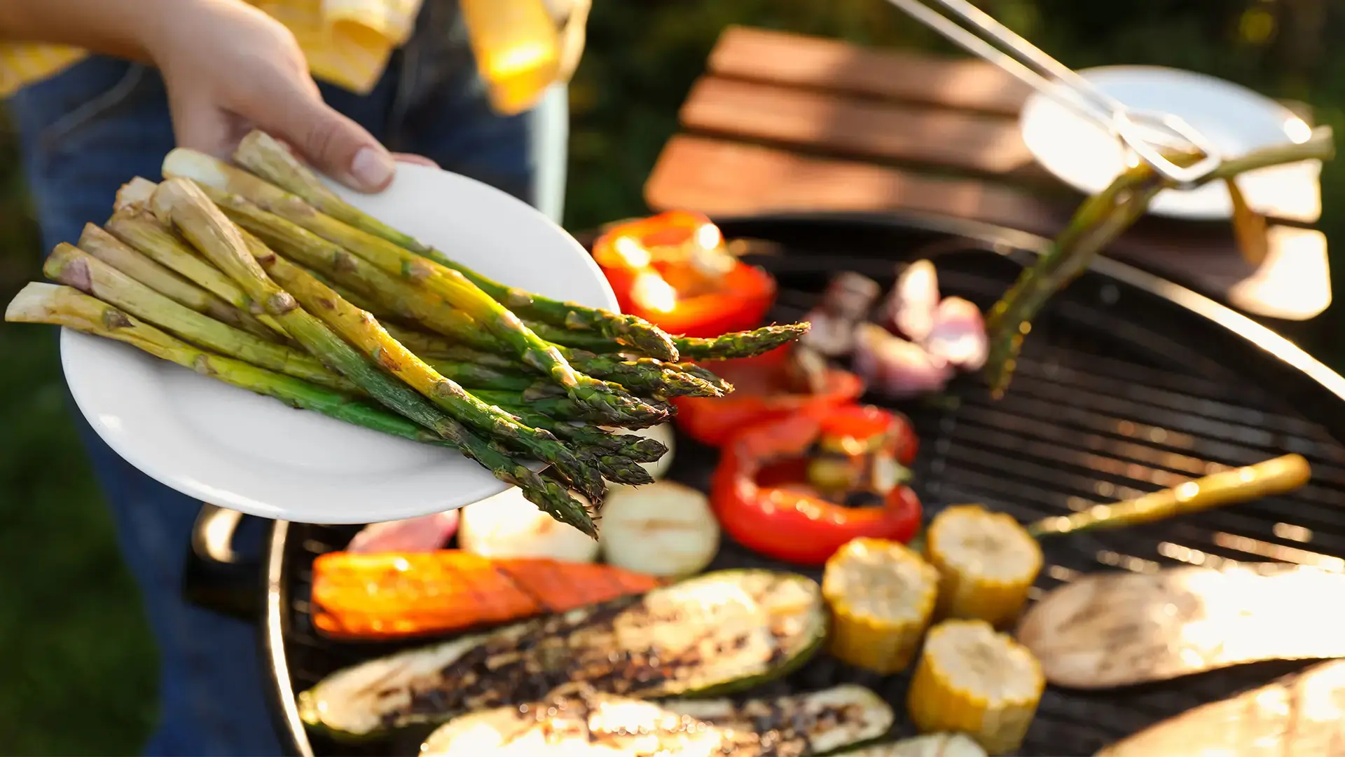 Woman cooking vegetables on barbecue grill outdoors